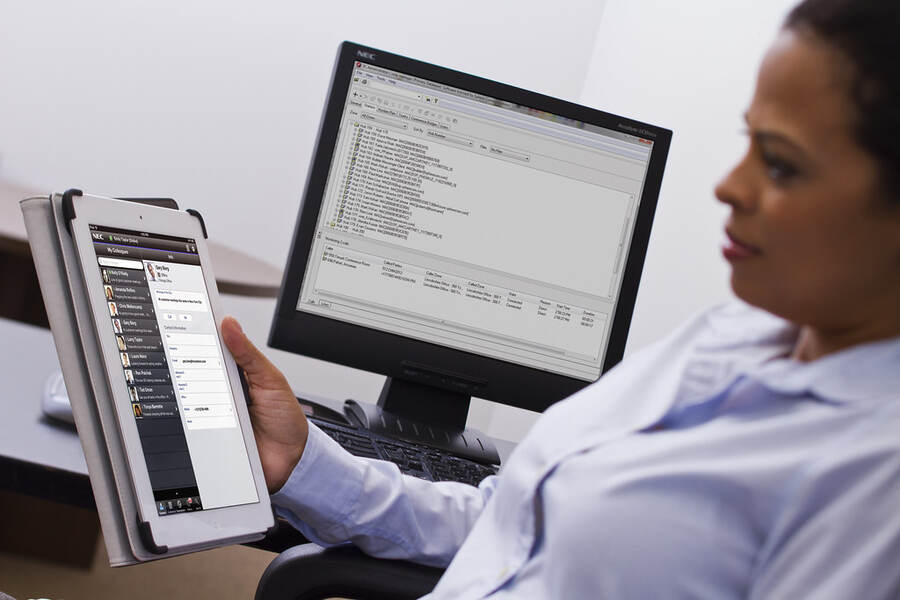 Someone working at a desk with a tablet and monitor