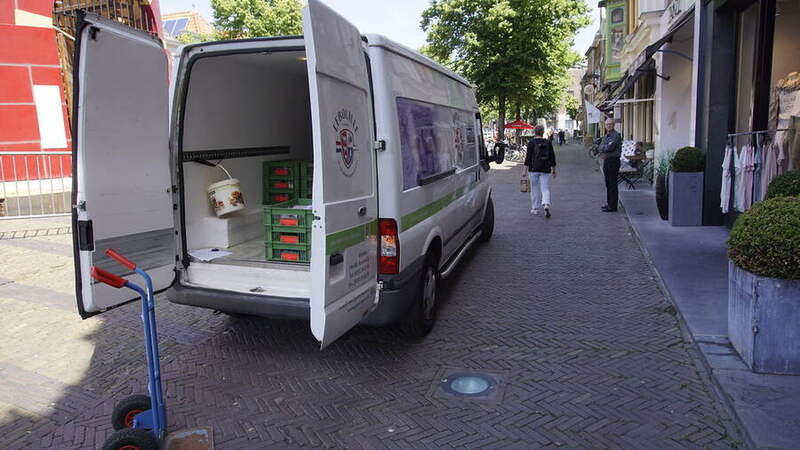 A delivery van being loaded on a street